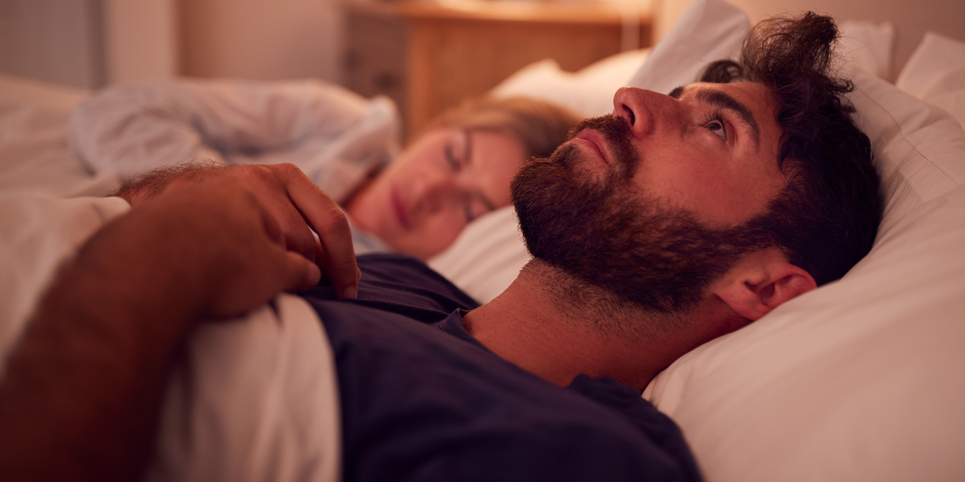 main in bed staring up at ceiling