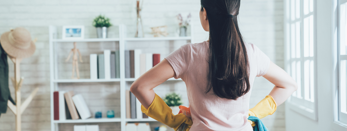 Back view of an housekeeper looking at the clean living room after she tidied up. young wife finished house chores putting hands in waist watching the bookshelf beside the sunlight window. | Doylestown Health